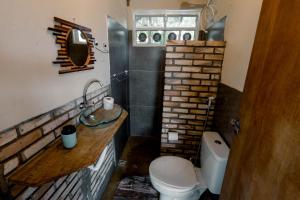 a small bathroom with a toilet and a sink at Chalé aconchegante, pertinho da cidade e conectada a natureza in Brasília