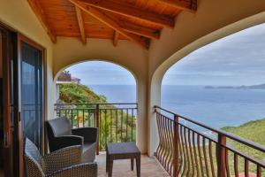 a balcony with chairs and a view of the ocean at Mount Healthy Villas 6- bedrooms with spa & pool in Tortola Island