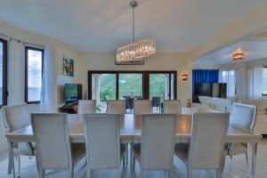 a dining room with a white table and chairs at Mount Healthy Villas 6- bedrooms with spa & pool in Tortola Island