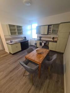 Habitación con mesa de madera, sillas y armarios. en Apartament Suite 3, en Bernburg