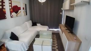 sala de estar con sofá blanco y TV en Excelsior II Vista, en Playa del Inglés