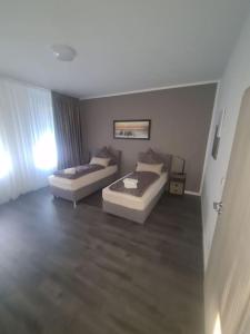 een woonkamer met 2 bedden en een bank bij Apartament Suite 3 in Bernburg