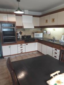 a kitchen with white cabinets and a black table at Pampa in San Carlos de Bariloche
