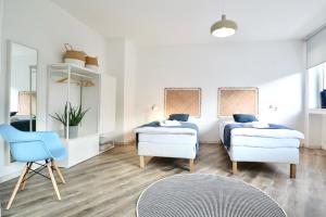 una sala de estar con 2 camas y una silla en BOHO APARTMENT: NETFLIX + BALCONY + BATHTUB en Essen