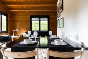 a dining room with a black table and chairs at Scandinavische blokhut op de Veluwe in Ermelo