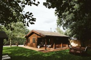 eine Holzhütte in einem Hof mit einem Grasfeld in der Unterkunft FINS Holiday Home in Ermelo