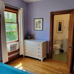 a bathroom with a white dresser and a toilet at Art and Lodging in South Bend