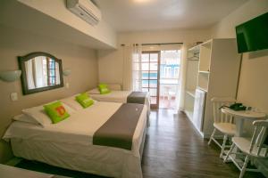 ein Hotelzimmer mit 2 Betten und einem Tisch in der Unterkunft Pousada Floratta Recanto da Ladeira in Gramado