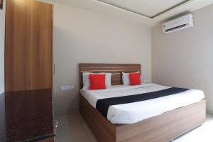 a bedroom with a large bed with red pillows at Hotel Gaurav Residency in Pune