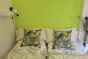 uma cama num quarto com paredes e almofadas verdes em Maison No.9 em Rosbach vor der Höhe