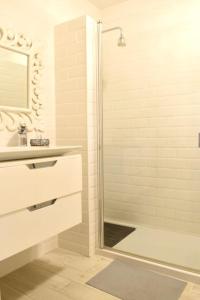La salle de bains est pourvue d'une douche et d'un lavabo. dans l'établissement Acogedor apartamento en Los Acantilados, à Acantilado de los Gigantes