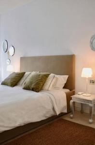 - une chambre avec un grand lit blanc et deux lampes dans l'établissement Acogedor apartamento en Los Acantilados, à Acantilado de los Gigantes