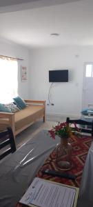 Zimmer mit einem Bett und einer Vase mit Blumen auf dem Tisch in der Unterkunft A metros de la Playa.... in Federación