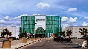 un grand bâtiment en verre vert dans un parking dans l'établissement Condominio Recanto das palmeiras, à Campos dos Goytacazes 7 autres photos