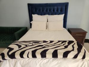 łóżko z czarno-białą kołdrą o paskach w obiekcie Bryanston Drive Elegant Guesthouse & Boardroom Facilities w mieście Johannesburg