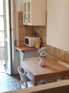 una cucina con tavolo e vaso di fiori di Chez Liviana a Roma