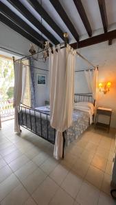 1 dormitorio con 1 cama con cortinas blancas en La Ventana, en Ibiza