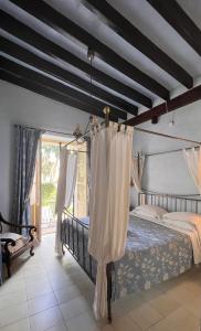 イビサ・タウンにあるLa Ventanaのベッドルーム(白いカーテン付きのベッド1台付)