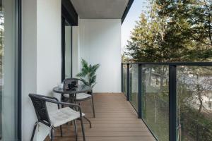 a room with a balcony with a table and chairs at Dziwnów River Side Apartment with Balcony by Renters Prestige in Dziwnów