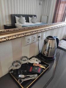 a tray with a tea kettle on a table in a hotel room at Klassik Hotel in Chişinău