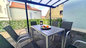 a table and chairs on a balcony with a bowl of fruit at Neuburg New Apartement in Neuburg an der Donau