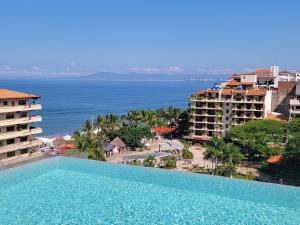 a large swimming pool in front of the ocean at Nayri Beach and restaurant row in Puerto Vallarta