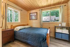 アシュフォードにあるCozy Cedar Cabin Steps Away From Mt. Rainierの木造キャビン内のベッド1台が備わるベッドルーム1室を利用します。