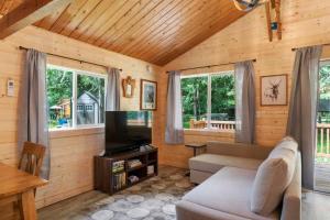 a living room with a couch and a television at Cozy Cedar Cabin Steps Away From Mt. Rainier in Ashford