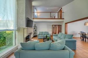 sala de estar con sofás azules y chimenea en La casa de los illos, casa completa con piscina en Sanxenxo en Sanxenxo
