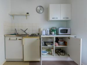 a kitchen with white cabinets and a microwave at Studio calme, proche centre, Wifi. in Belfort