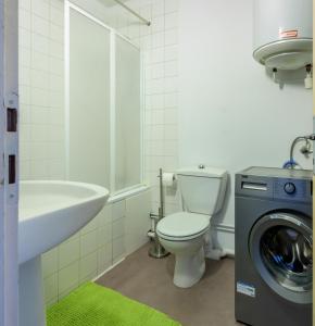 a bathroom with a toilet and a sink and a washing machine at Studio calme, proche centre, Wifi. in Belfort