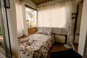 um pequeno quarto com uma cama e uma janela em Chalé charmoso e aconchegante, pertinho da cidade. em Brasília