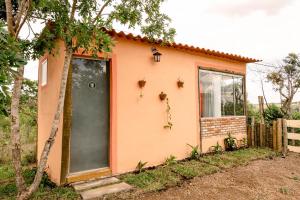 uma pequena casa rosa com uma porta verde em Chalé charmoso e aconchegante, pertinho da cidade. em Brasília