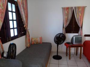 a room with a couch and a tv and windows at Residência Pancho Villa in Canoa Quebrada