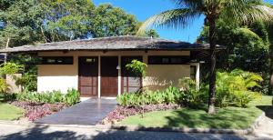 une maison avec un palmier devant dans l'établissement Trancoso Terravista Villa Floresta, à Trancoso