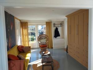 a living room with a yellow couch and a chair at Tiny house Wakker in Eemnes