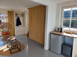 a kitchen with a counter and a chair and a table at Tiny house Wakker in Eemnes