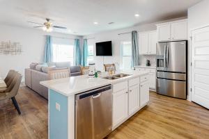 a kitchen with white cabinets and stainless steel appliances at Sun of a Beach 3 in Saint Joe Beach