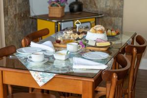 einen Tisch mit einem Frühstück mit Brot und Kaffee in der Unterkunft Pousada Floratta Recanto da Ladeira in Gramado