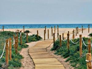 einen Holzweg zum Strand in der Unterkunft Apartamento Sofía II a 500m de la playa con Parking solo para motos y bicicletas in Puerto de Sagunto