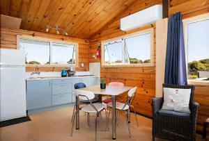 a kitchen with a table and chairs in a cabin at Driftwood Cottage in Punakaiki
