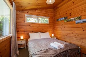 a bedroom with a bed in a log cabin at Driftwood Cottage in Punakaiki