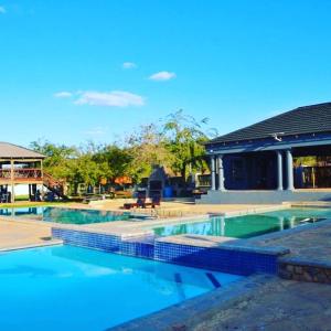 a swimming pool in front of a house at 1 OAK Resort in Thohoyandou