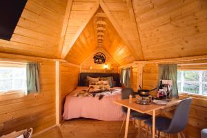 ein Schlafzimmer in einem Blockhaus mit einem Bett und einem Tisch in der Unterkunft Le Kota B&B 4**** 