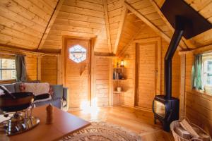 Cette cabane en rondins comprend un salon avec un poêle à bois. dans l'établissement Le Kota B&B 4****, 