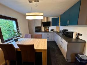 a kitchen with a wooden table and a kitchen with blue cabinets at Zimmervermietung Hirschmann Nürnberg/Messe in Nürnberg +8 photos
