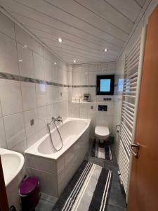 a white bathroom with a tub and a toilet at Zimmervermietung Hirschmann Nürnberg/Messe in Nuremberg