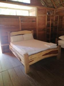 a bed in a wooden room with two bunk beds at Cabanas Las Estrellas in Palomino