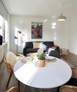 uma sala de estar com uma mesa branca e um sofá em BOHO APARTMENT: NETFLIX + BALCONY + BATHTUB em Essen