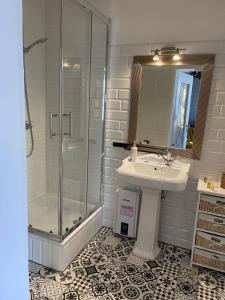 ein Bad mit einem Waschbecken und einer Dusche in der Unterkunft Gutshauszimmer Premium in Neu Gaarz